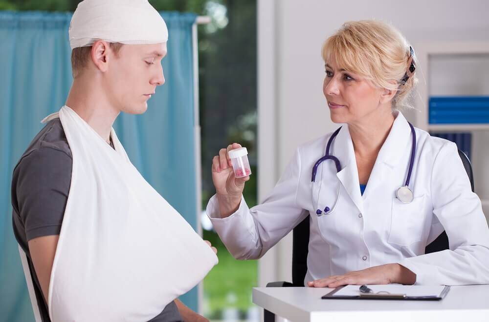 Doctor giving medicine to the driver who is inured in the head from car accident.